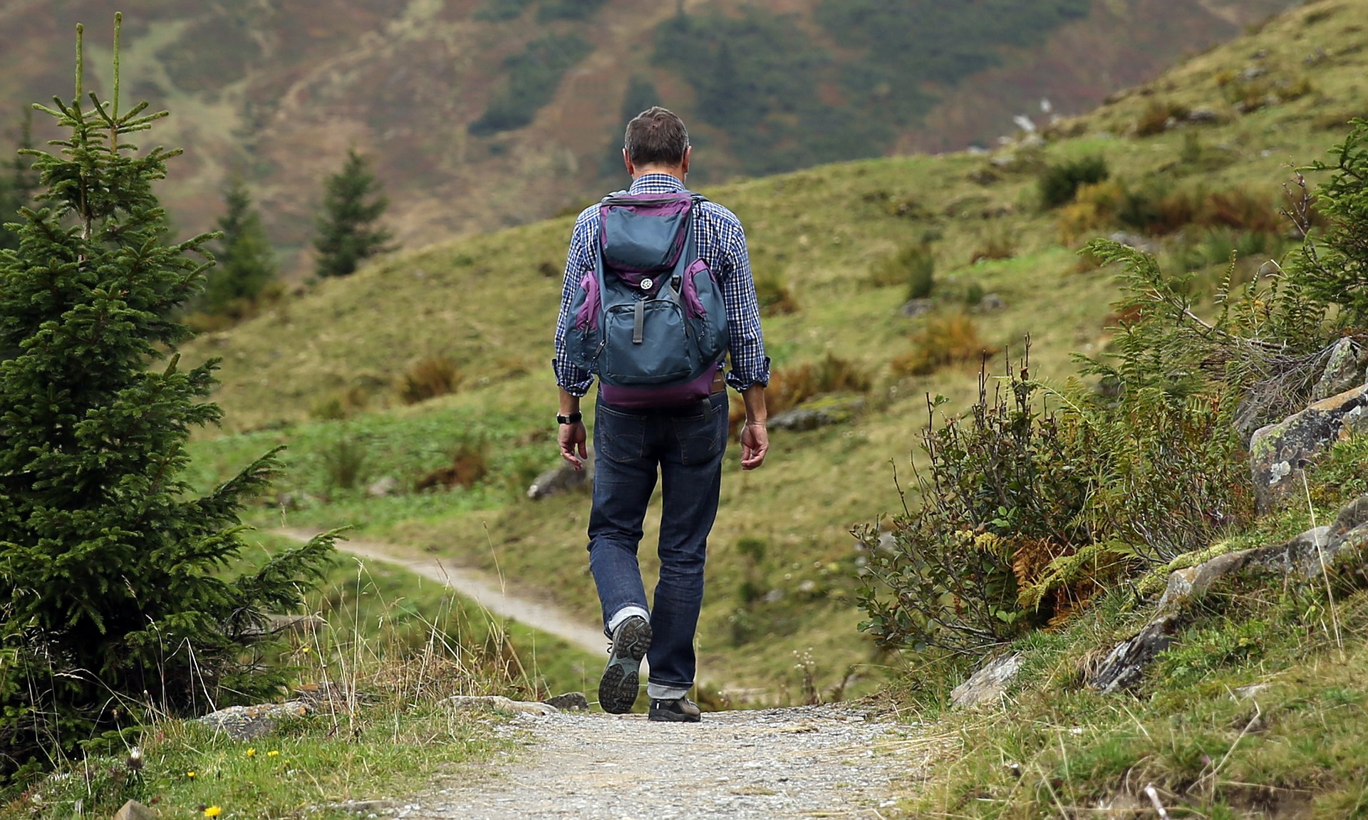 man walking on a mountain path